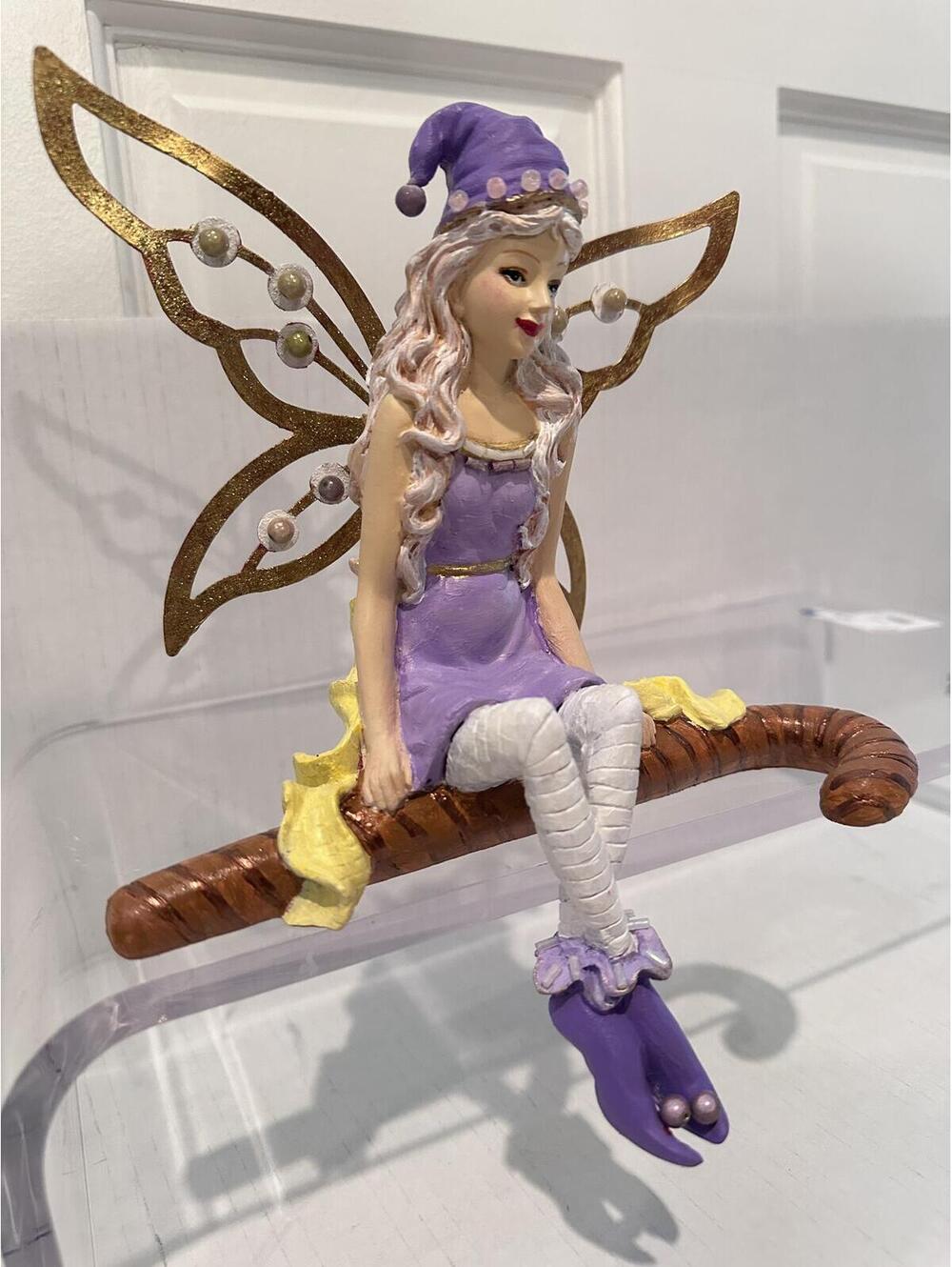 Figurine Seated Fairy with Long, Wavy Blonde Hair and Vibrant Purple Attire
